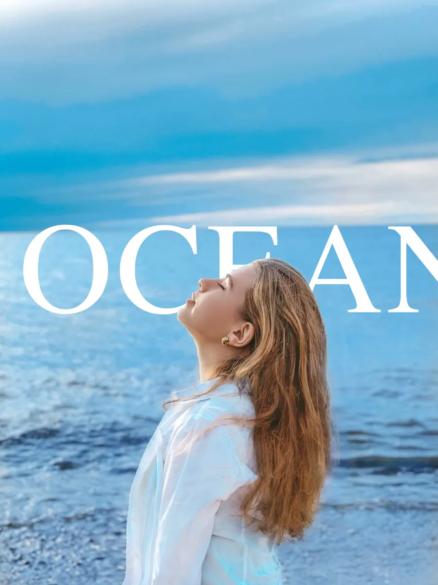 Text behind image example - OCEAN text overlaid behind woman portrait at beach